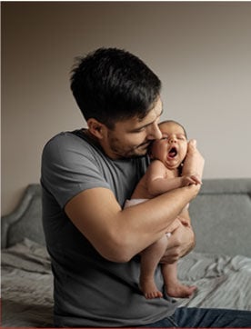 Padre emocionado abrazando a bebé